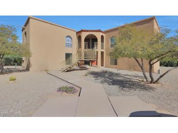 Inviting condo exterior with desert landscaping, an arched entryway, and stair access to upper units at 13035 N 34Th St # 7, Phoenix, AZ 85032