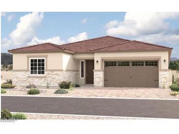 Charming single-story home boasts stone accents, a two-car garage, and a beautifully landscaped front yard at 15846 W Bronco Trl, Surprise, AZ 85387