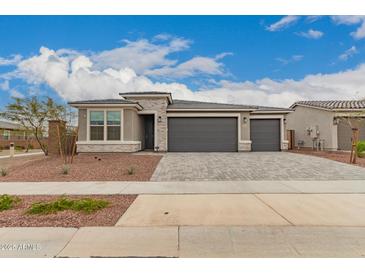 Charming single-story home with a three-car garage and stone accents at 17845 W Red Fox Rd, Surprise, AZ 85387