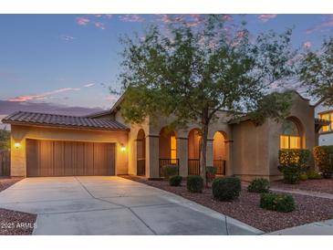 Charming single-Gathering home featuring a two-car garage and well-manicured landscaping at dusk at 21008 W Cora Vis, Buckeye, AZ 85396