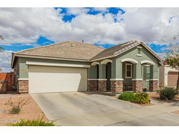 Charming single-story home featuring a two-car garage and a well-maintained front yard under a partly cloudy sky at 22552 E Via Estancia --, Queen Creek, AZ 85142