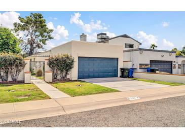 Beige home featuring a two-car garage, gated entryway, and low-maintenance landscaping at 905 E Marco Polo Rd, Phoenix, AZ 85024