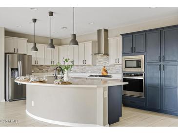 Bright kitchen boasts white cabinets, stainless steel appliances, and a large island perfect for entertaining at 9743 E Torino Ave, Mesa, AZ 85212