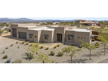 Contemporary home with a flat roof, desert landscaping, and an attached garage at 14328 E Peak View Rd, Scottsdale, AZ 85262