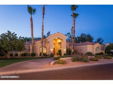 Stunning single-story home featuring a well-maintained landscape, mature palm trees, and a classic Southwest architecture at 6132 E Yucca St, Scottsdale, AZ 85254