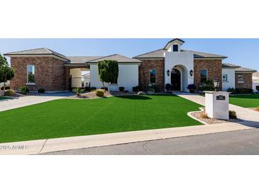 Striking front exterior with stone accents, manicured lawn, and inviting curb appeal at 7482 S Mccormick Way, Queen Creek, AZ 85142