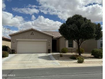 Charming single story home featuring a two car garage, desert landscaping, and beautiful mature shade tree at 10 N Agua Fria Ln, Casa Grande, AZ 85194