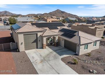 Stunning home featuring solar panels, a two-car garage, a paved driveway, and desert landscaping at 10256 W Appaloosa Trl, Casa Grande, AZ 85194