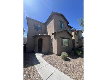 Two-story home featuring a stucco exterior, arched entryway, and low-maintenance gravel landscaping at 1709 W Pollack St, Phoenix, AZ 85041