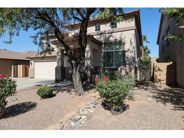 Charming two-story home featuring a low-maintenance desert landscape and inviting curb appeal at 17474 W Acapulco Ln, Surprise, AZ 85388