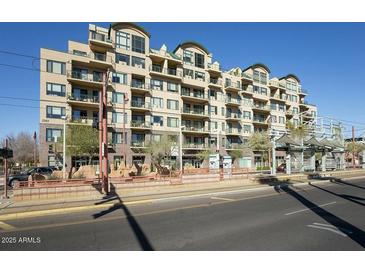 Multi-story condo building featuring balconies, mature landscaping and a city transit stop out front at 2302 N Central Ave # 412, Phoenix, AZ 85004