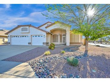 Charming single-story home featuring a well-manicured desert landscape and a spacious three-car garage at 3037 S Coyote Cyn, Mesa, AZ 85212