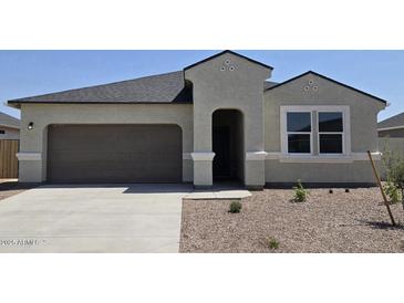 Charming single-story home featuring a two-car garage, neutral stucco, and well-maintained landscaping in a sunny setting at 5735 E Axle Ln, San Tan Valley, AZ 85140