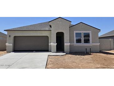Charming single-story home with a gray exterior, a two-car garage, and a well-manicured lawn at 5735 E Axle Ln, San Tan Valley, AZ 85140