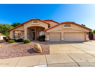 Charming single-story home with well-maintained landscaping, desert rock yard, and a two-car garage at 7810 W Wescott Dr, Glendale, AZ 85308