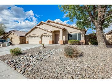 Charming single-story home with a three-car garage and desert landscaping under a sunny, partly cloudy sky at 9174 W Marconi Ave, Peoria, AZ 85382