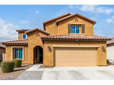 Charming two-story home featuring a terracotta roof, yellow stucco, and a two-car garage at 10816 W Nosean Rd, Peoria, AZ 85383