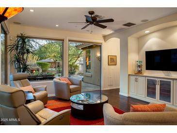 Inviting living room with floor-to-ceiling windows, comfortable seating and outside fireplace views at 11496 E Pine Valley Rd, Scottsdale, AZ 85255