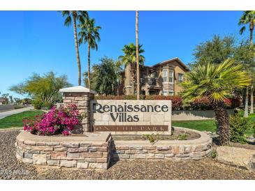 Landscaped Renaissance Villas community sign with colorful flowers and a clear view of the community buildings at 14250 W Wigwam Blvd # 1022, Litchfield Park, AZ 85340