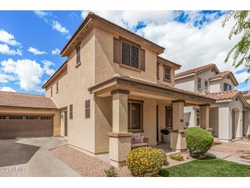 Charming two-story home featuring a covered porch, landscaped yard, and a two-car garage at 2116 S Moccasin Trl, Gilbert, AZ 85295