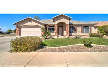 Charming single-story home with a well-maintained lawn, brick accents, and a two-car garage at 3542 E Pala Ct, Gilbert, AZ 85297