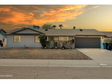 Charming single-story home with a two-car garage and xeriscaped front yard at sunset at 3619 E Friess Dr, Phoenix, AZ 85032