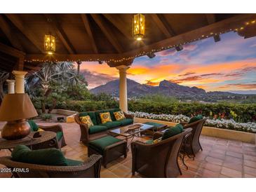 Comfortable patio with wicker seating and a stunning sunset view of the mountains, perfect for outdoor relaxation at 5254 E Arroyo Rd, Paradise Valley, AZ 85253