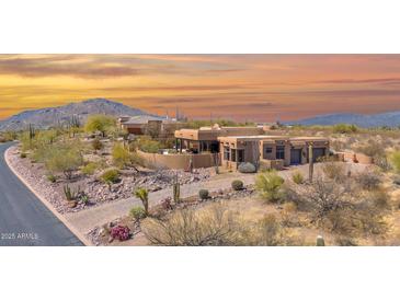 Desert home at sunset, showcasing Southwestern architecture, mature landscaping, and mountain views at 8154 E Tecolote Cir, Scottsdale, AZ 85266