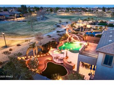 Aerial view of a backyard pool and spa featuring a large rock waterfall and lush landscaping at 2678 E Firestone Dr, Chandler, AZ 85249