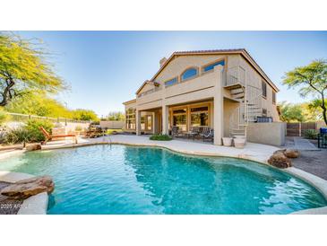 Inviting backyard pool with spiral staircase access to the upper balcony and an outdoor kitchen area at 7418 E Sandia Cir, Mesa, AZ 85207