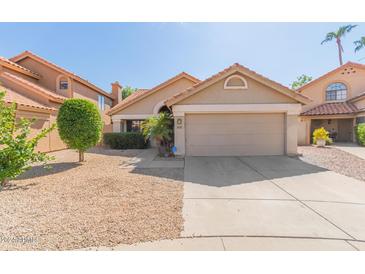 Charming home featuring a terra cotta tile roof, desert landscaping, and an attached two-car garage in a sunny neighborhood at 830 N Cholla St, Chandler, AZ 85224