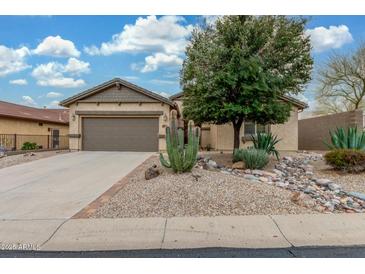 Charming single-story home featuring desert landscaping, a two-car garage and neutral colors at 1197 W Rolls Rd, San Tan Valley, AZ 85143