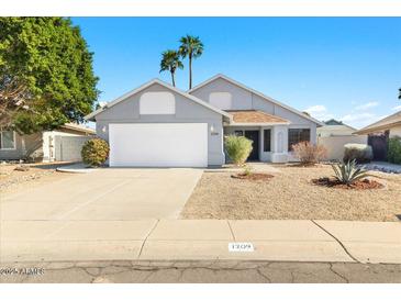 Charming single-story home featuring a two-car garage, desert landscaping, and a neutral color palette at 1209 N 87Th St, Scottsdale, AZ 85257