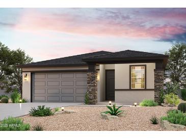 Beautiful single-story home with a two-car garage and desert landscaping at 18243 W Daley Ln, Surprise, AZ 85387
