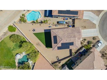 An aerial view of a backyard including a pool, desert landscaping, and solar panels at 41734 N Cielito Linda Way, San Tan Valley, AZ 85140