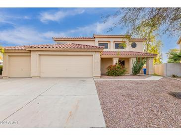 Charming two-story home with a red tile roof, three-car garage, and desert landscaping at 4831 N 93Rd Dr, Phoenix, AZ 85037