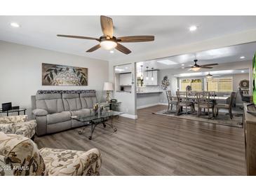 Spacious living room boasts stylish furniture and an open layout leading to the dining area and kitchen at 5006 E Forge Ave, Mesa, AZ 85206