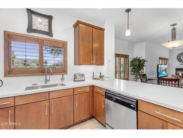 Charming kitchen with quartz countertops, wood cabinets, stainless dishwasher, and natural light at 5350 E Deer Valley Dr # 1419, Phoenix, AZ 85054