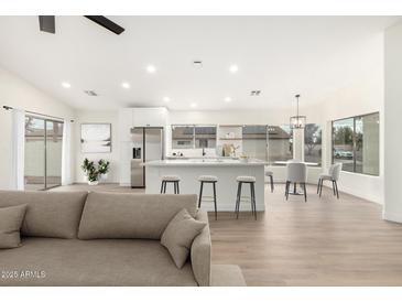 Open floor plan featuring a kitchen island with barstool seating and stainless steel appliances at 7056 W Caron Dr, Peoria, AZ 85345
