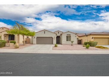 Charming single-story home with a well-manicured front yard and two car garage at 1827 S 237Th Dr, Buckeye, AZ 85326