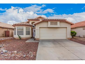 Charming single-story home featuring a tile roof, desert landscaping, and a two-car garage at 7929 W Wescott Dr, Glendale, AZ 85308