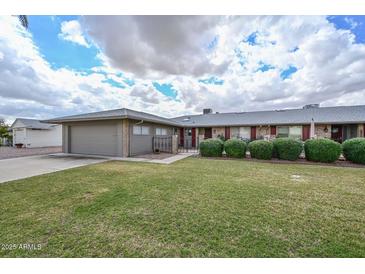 Charming single-story home featuring a well-manicured lawn and desert landscaping at 10317 W Desert Forest Cir, Sun City, AZ 85351