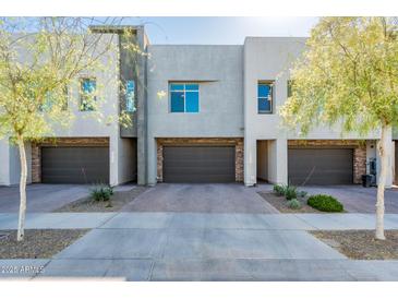 Contemporary townhome exterior featuring stone accents, private garages, and manicured landscaping at 25339 N 19Th Ln, Phoenix, AZ 85085