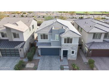 A modern two-story home with a stone facade, well-manicured landscaping, and a two-car garage at 2855 E Tina Dr, Phoenix, AZ 85050