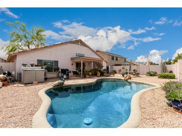 Inviting backyard pool with patio and desert landscaping, perfect for outdoor entertaining and relaxation at 8568 W Purdue Ave, Peoria, AZ 85345