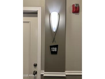 Hallway features a modern wall sconce and apartment number sign near a white door at 1701 E Colter St # 138, Phoenix, AZ 85016