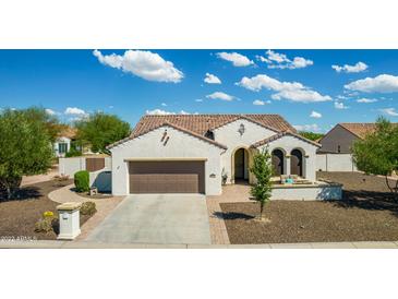 Charming single-story home featuring a well-manicured front yard, a two-car garage, and a cozy front porch at 1775 N 164Th Dr, Goodyear, AZ 85395