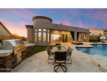 Outdoor kitchen, dining area, pool, and lounge offer premier backyard living at 2333 N 87Th Pl, Mesa, AZ 85207