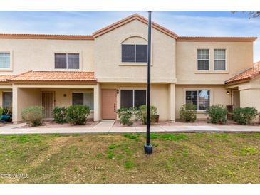 Charming two-story townhome with a traditional stucco exterior and a well-manicured front lawn at 5808 E Brown Rd # 42, Mesa, AZ 85205