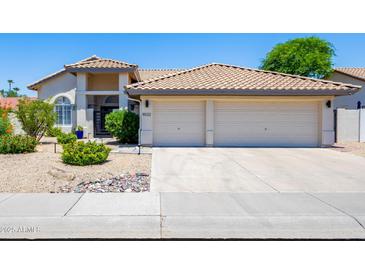 Charming home featuring a spacious two-car garage and well-maintained front yard landscaping at 9032 E Larkspur Dr, Scottsdale, AZ 85260